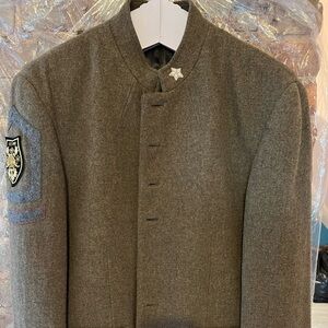 Militant looking light coat with multiple badges in olive green.